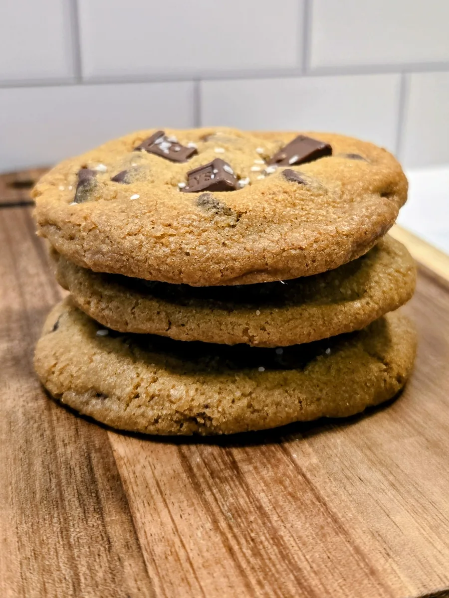 A stack of chocolate chip cookies on a wooden board