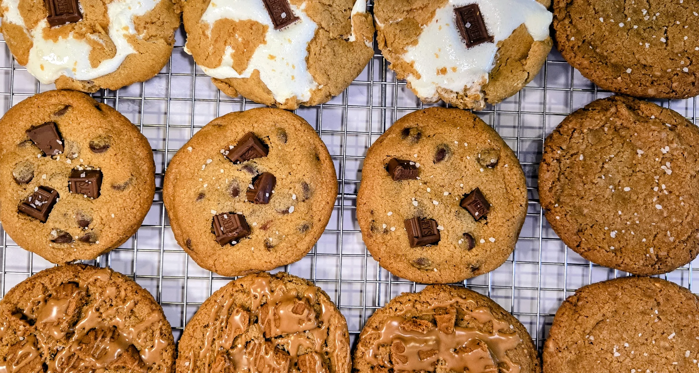 Chocolate chip, s’mores and cookie butter cookies cooling on a wire rack